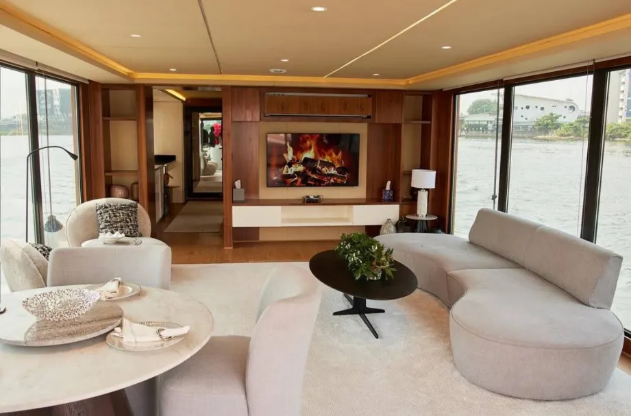 Interior lounge of a luxury boat with panoramic windows over the Lagos water
